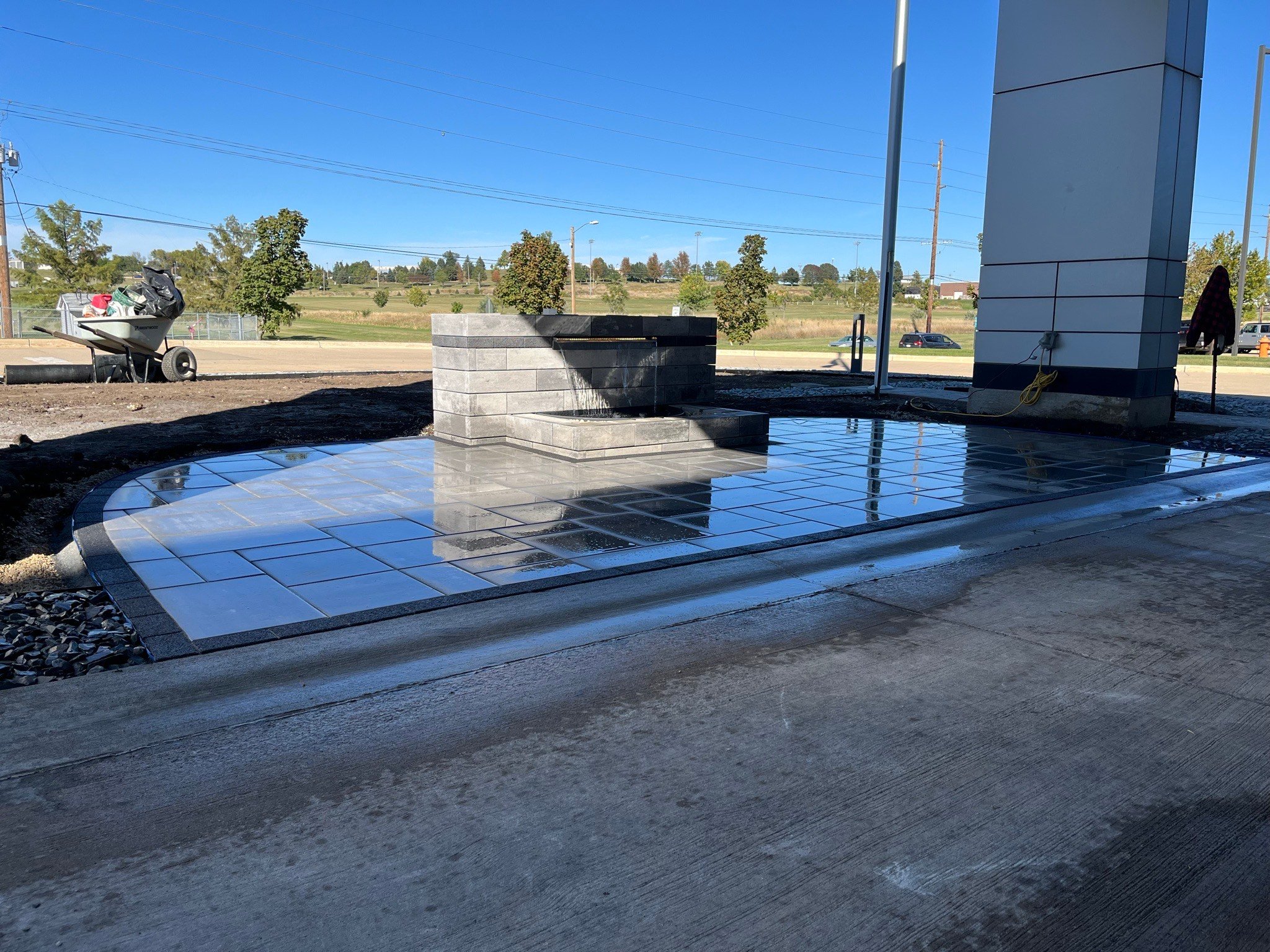 Modern concrete water feature with reflective tiles near urban building