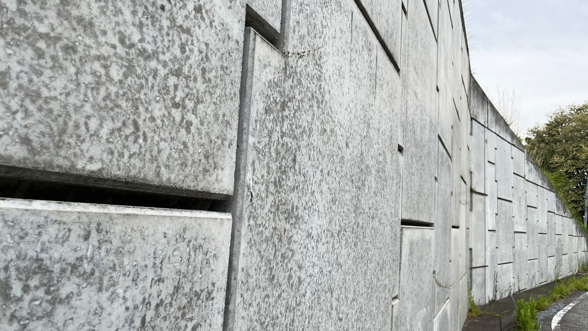 Weathered concrete wall with geometric panels and textured surface